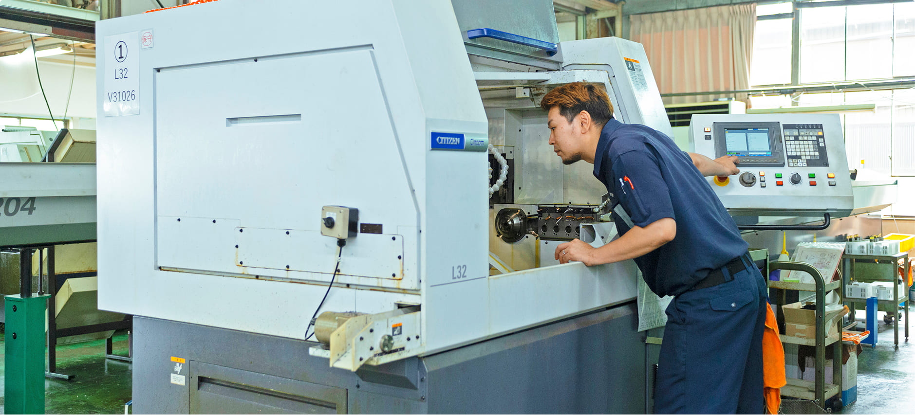 CNC旋盤を触っている写真,野村精機